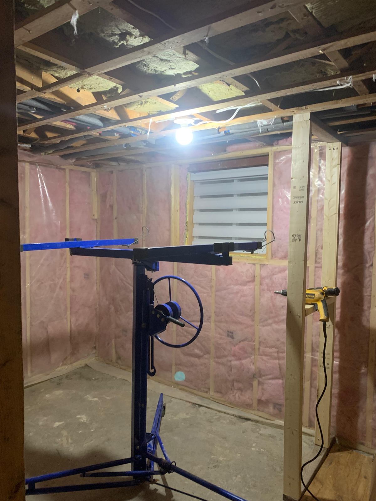 Basement insulation, vapor barrier installation, and utility framing setup